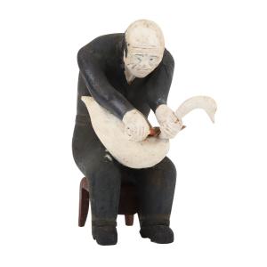 Painted carved wood sculpture by Collins Eisenhauer (Nova Scotia, 1898-1979), depicting a man sitting on a brown stool carving a swan, circa 1975, 6 inches tall. Estimate: CA$6,000-$8,000