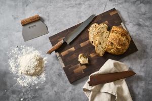 STEELPORT Bench Scraper, STEELPORT Bread Knife, and Bread Knife Sheath next to a loaf of bread