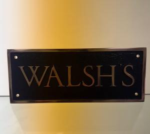 A plaque made by Award by Walsh with the name "Walsh's" engraved.