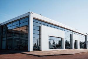 A modern white car building with a flat roof and glass walls