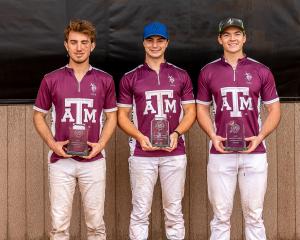 Three male polo players stand facing camera in maroon jerseys