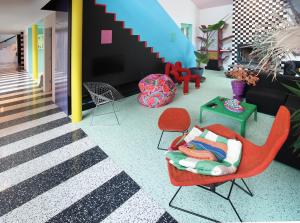 Terrazzo design: stripes in terrazzo in the hall next to green terrazzo floor in a room with bright artwork