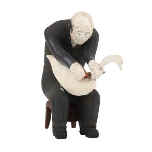 This 6-inch-tall painted carved wood sculpture by Collins Eisenhauer (Nova Scotia, 1898-1979), depicting a man in black clothes sitting on a brown stool carving a swan, settled at CA$12,980.