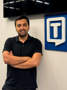 Siyar Işık, CEO of Tor.app, standing in front of the Tor.app logo—creator of AI productivity tools like Transkriptor for transcription, Eskritor for content writing, and Speaktor for text-to-speech.