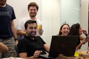 Team members at Tor.app smiling and working together during a collaboration session, developing AI tools for transcription, content generation, and text-to-speech.