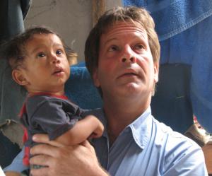 Author and human rights activist Patrick Atkinson rescues a small Guatemalan boy from village affected by Mount Fuego volcanic eruption