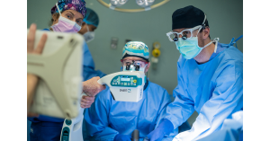Surgeons in an operating room use the SMART-C portable mini C-arm to capture real-time fluoroscopic images during surgery.