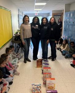 Blue Ribbon Foundation Board Members, Tiffany Tinson, Kim Coley-Thomas, President Nancy Al-Omoush and Lisa Jones at launch of TCS’s Lutheran Schools Week Cereal Domino Train (Photo Credit: The Chapel School / Kate Marino)