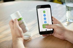Person using the PillConnect Bottle and smartphone app