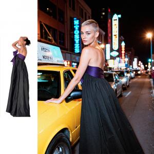 A NYC street night scene with a young model leaning over a yellow cab