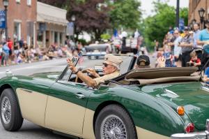 A veteran drives an antique car past spectators on Union Street in Kennett Square, PA.