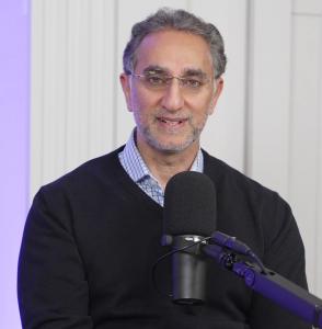Zafir Rashid headshot image in studio with on-air microphone.