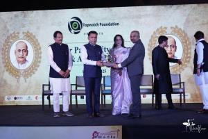 Dr. Mohana Rao Patibandla receives an award from Chief Minister Dr. Pramod Sawant, with Hema Malini and other dignitaries present on stage at the Sardar Patel Unity Summit & Awards 2025 in Goa.