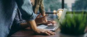 Businesspeople around a laptop