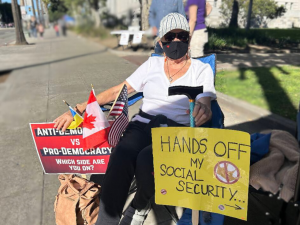 Senior citizen in chair with cane at a rally to protect Social Security