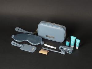 China Airlines x MOSCHINO Business Class amenity kit featuring a blue travel pouch, eye mask, luggage tag, toothbrush set, and Moroccanoil skincare products.