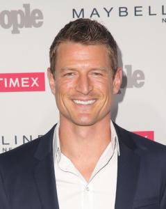 Actor Philip Winchster dressed in a suit on the red carpet.