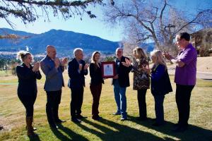 Craig Martelle, Chairman of International Association of SF&F Authors, presenting a framed recognition for the 75th anniversary of To the Stars by L. Ron Hubbard to Emily Goodwin, VP Public Affairs Author Services, Inc., at the base of Cheyenne Mountain.