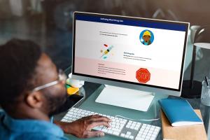 Man sitting at a desk viewing an online training module on a computer screen about defining illicit drug use, part of a Reasonable Suspicion Training Program