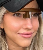 young woman wearing a baseball cap and monocular AR headset