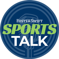 Blue circle with green and white lettering that says Foster Swift Sports Talk