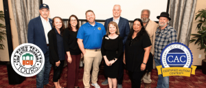 A group of people poses together at an event, with badges for Old Town Trolley Tours and Certified Autism Center displayed.