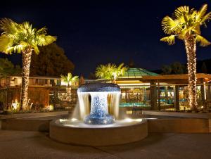 a fountain with warm steaming waters and pool and gazebo in background