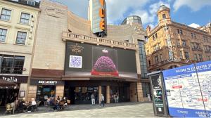 Couture rose sculpture projected by Imaginary Worlds on Leicester Square’s central screen, featuring a purple floral dress.