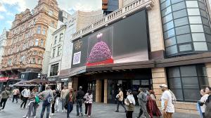 Imaginary Worlds projection of a rose dress sculpture in central London, combining preserved florals and digital display.