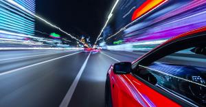 image of red car seeming to be speeding with blurry foreground