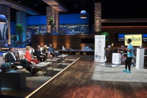 Robbie Cabral pitching BenjiLock to the investors on Shark Tank, standing confidently in front of the product display during his television appearance.