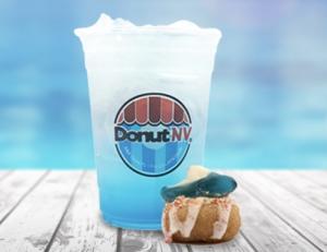 A photo of a mini donut topped with homemade glaze and a gummy shark paired with a blue colored lemonade