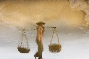 Impressionist photography of a woman’s reflection in water, captured in soft natural light