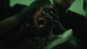 A close-up from the “Speechless” music video showing Jakub Chmelar surrounded by dark-painted hands gripping his face and chest, symbolizing societal pressure, inner conflict, and the fight for self-expression.