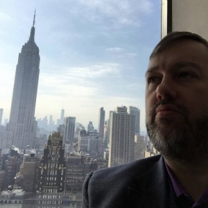Karl Smith Director of Decision Point in Grace Building in NYC with Empire State building out the window