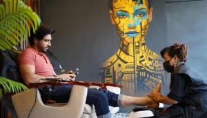 Pakistani celebrity enjoying a relaxing foot treatment at Estheticare, with artistic wall decor in the background.