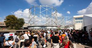 Crowds explore Maker Faire Rome  at Rome’s iconic Gazometro under sunny skies.