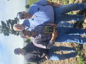 Rene Orozco holding award plaque and 3 members of the farm team