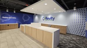 Interior of Revity Federal Credit Union in Greensboro, NC, featuring a reception area with custom wall graphics and an acrylic logo sign produced and installed by Heritage Signs & Displays.