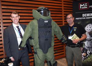 Alexander Landry and Mark Paine from Mriya Aid at the 2025 NATO Association of Canada's "Safeguarding Ukraine's Future" Conference in Toronto standing next to the iconic Med-Eng EOD9 Bomb Suit and helment