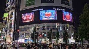 Nighttime billboard in Tokyo featuring Imaginary Worlds Flower Lamp with glowing forever roses and dynamic lighting.