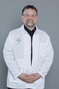 Dr. Ryan Zaklin, Medical Director in white lab coat with ECS Wellness logo
