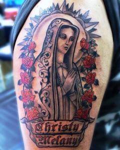 Christian-themed Virgin Mary tattoo with red roses and religious detailing by Nashville tattoo artist Elvis.
