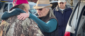 Pastor Penny Baker places a comforting hand on a community member’s shoulder during a street outreach, as seen in a scene from the documentary Take the Meat to the Streets.