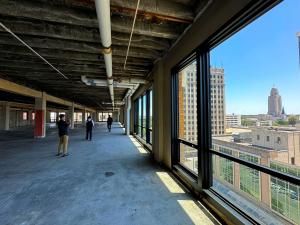 Interior view of Elevator's new co-warehousing and office space in Lincoln, Nebraska, featuring large windows overlooking the downtown skyline, including the Nebraska State Capitol Building.