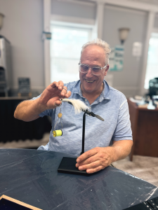Man focusing on tying a fly before fishing