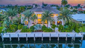 Luxury waterfront home in Harbor Beach at twilight with pool and illuminated exterior