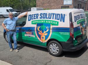 Darrell Keith stands near his Deer Solution branded vehicle.
