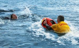 Lifeguard using a SEABOB RESCUE to rapidly approach a distressed swimmer during a water rescue operation.