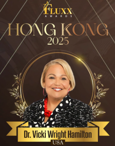 Dr. Vicki Wright Hamilton smiling in front of a gold laurel and black backdrop at the 2025 FLUXX Awards in Hong Kong, where she received the Business Growth Strategist Woman of the Year – Consulting (USA) honor.